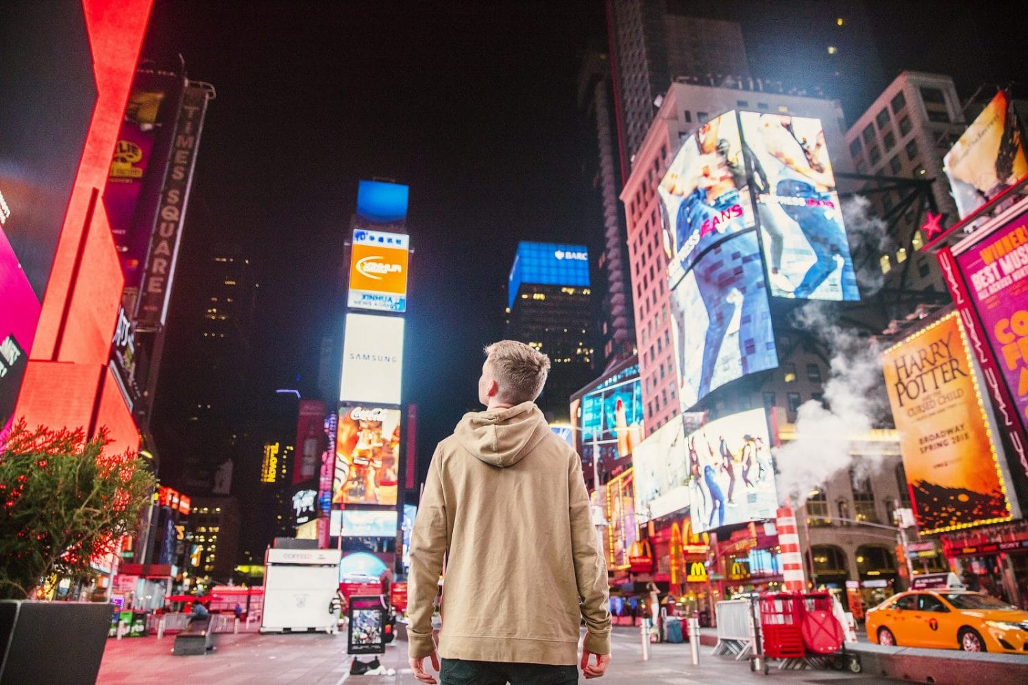 Qué es el RGPD y cómo cumplirlo en WordPress 9 Una persona en Time Square contemplando una gran cantidad de anuncios